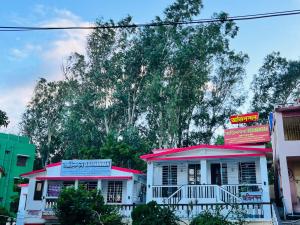 a white and pink building with a sign on it at Pebbles Guest House Digha in Digha
