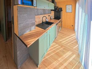 a kitchen with a sink and a wooden floor at Les Terrasses du Grillon in Chambon-sur-Lac