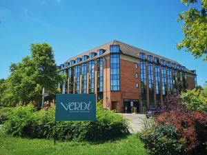 a large building with a sign in front of it at Verdi Budapest Aquincum in Budapest