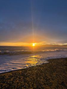 a sunset on a beach with the ocean at Bahia de Mazarrón in Puerto de Mazarrón