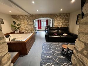 a living room with a couch and a tub at Appart Spa Privatif in Reims