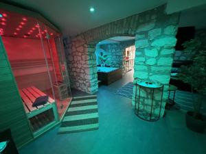 a room with a stone fireplace and a room with a bench at Appart Spa Privatif in Reims