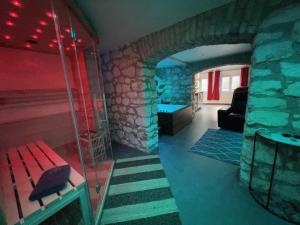 a room with a stone wall and a red bench at Appart Spa Privatif in Reims +13 photos