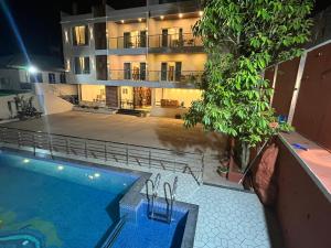 an apartment building with a swimming pool in front of it at Gugal Bliss in Mahabaleshwar