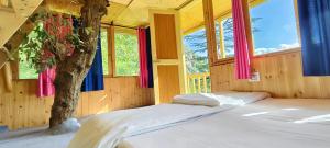 a bedroom with a bed and a tree in it at Jibhi Pine Nature Tree house in Jibhi +13 photos