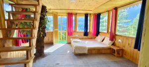 a bedroom with a bed in a room with windows at Jibhi Pine Nature Tree house in Jibhi