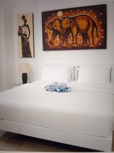 a bedroom with a white bed with a painting on the wall at Star light hotel in Monterrey