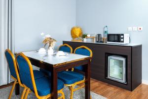 a dining room with a table and chairs and a microwave at Golden Garden Al Corniche in Dammam