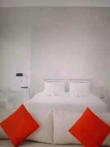 a bedroom with a white bed with two orange pillows at Star light hotel in Monterrey +4 photos