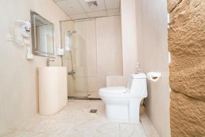 a white bathroom with a toilet and a shower at Golden Garden Al Corniche in Dammam +63 photos