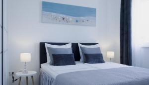 a bedroom with a large bed with blue pillows at Apartments King and Queen 2 in Povile +16 photos