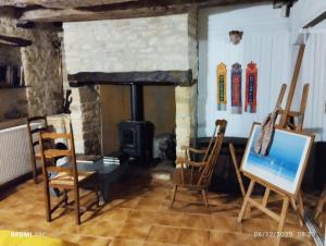 a living room with chairs and a wood stove at La Chambre Périgourdine in Journiac
