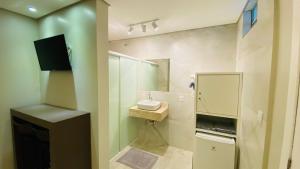 a bathroom with a shower and a sink and a mirror at Pousada Jabuticabeira in Jaguaruna +91 photos