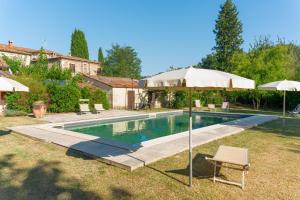 a swimming pool with two umbrellas and two chairs at B&B Il Molinello in Asciano