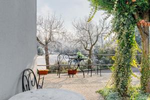 a patio with a table and chairs and vines at Le Dimore Apartments - Garden & Private Parking in Verona