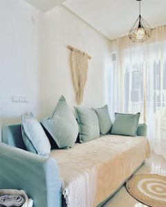 a couch with blue pillows in a living room at Palmeras Puerto Torrevieja in Torrevieja
