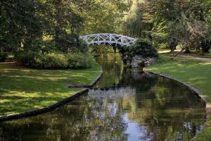 a river with a white bridge in a park at Hotel Guzy Lier Centre in Lier