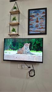 a flat screen tv hanging on a wall with a leopard at Kripanidhi Homestay in Jodhpur