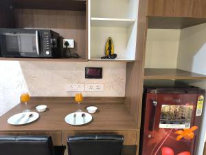 a small kitchen with a table and a refrigerator at Aerovista Suites - Neon Homeotel- 1 kms from Airport in Pune