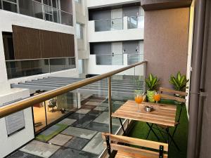 a balcony with a table and two glasses on it at Aerovista Suites - Neon Homeotel- 1 kms from Airport in Pune