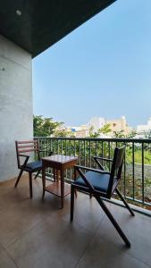 a patio with two chairs and a table on a balcony at Savana Stay - A Boutique Hotel in Pondicherry
