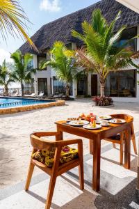 a table with food on it next to a resort at S&S HOTEL in Jambiani
