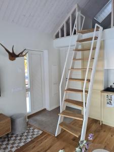 a white spiral staircase in a room with a ceiling at Salmistu Saunamaja in Salmistu