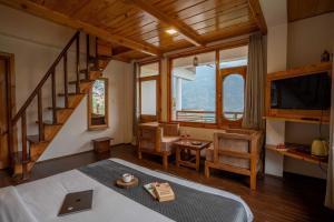 a room with a bed and a desk and a staircase at THE LANDSBY COTTAGES in Nagar