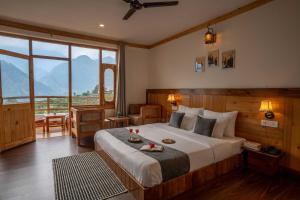 a bedroom with a large bed with a large window at THE LANDSBY COTTAGES in Nagar