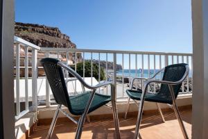two chairs on a balcony with a view of the beach at Pensión La Gaviota in Playa de Santiago