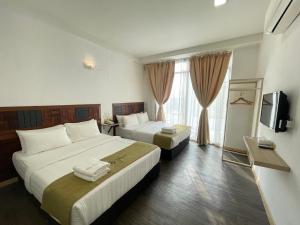 a hotel room with two beds and a television at S8 Boutique Hotel near KLIA 1 & KLIA 2 in Sepang
