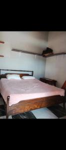 a bedroom with a wooden bed with white sheets at Loft centro de el tabo in El Tabo