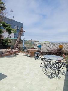 a patio with tables and chairs and a playground at Loft centro de el tabo in El Tabo