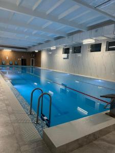 a large swimming pool with blue water in a building at Галичанка Еліт SPA in Gornyak