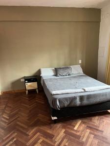 a bedroom with a bed and a side table at Casa balcarce in Salta