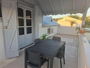 a black table and chairs on a patio at Spacious 2 beds flat in Grande-Terre center in Morne-à-lʼEau