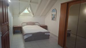a small bedroom with a bed and a window at Spacious 2 beds flat in Grande-Terre center in Morne-à-lʼEau