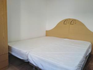 a bed with a wooden headboard in a room at Condomínio Equestre in Golegã
