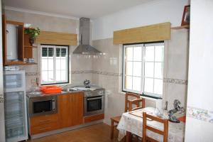 a kitchen with a sink and a stove and windows at Condomínio Equestre in Golegã