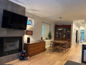 a living room with a fireplace and a dining room at Ride and Climb Lodge in Squamish