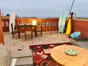 a patio with a table and surfboards on a balcony at Ahmed mirleft in Sidi Ifni +16 photos