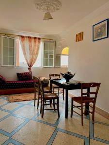 a living room with a table and chairs and a couch at Ahmed mirleft in Sidi Ifni