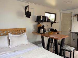 a bedroom with a bed and a table and a desk at Nomade Balmaceda in Balmaceda