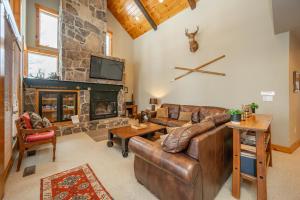 a living room with a leather couch and a fireplace at WISPer by Railey Vacations in McHenry