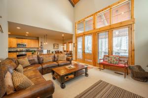 a living room with a leather couch and a coffee table at WISPer by Railey Vacations in McHenry +35 photos