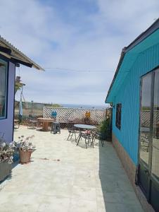 a patio with a table and chairs next to a blue building at Departamento interior centro de el tabo in El Tabo +13 photos