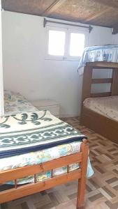 a bedroom with two bunk beds and a window at Departamento interior centro de el tabo in El Tabo