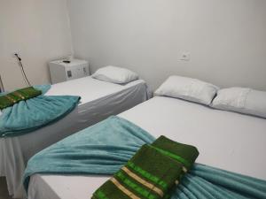 two beds with towels on them in a room at Hotel Stones in Jaraguá