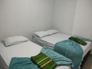 two beds with towels on them in a room at Hotel Stones in Jaraguá