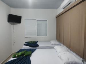 a room with two beds and a television in it at Hotel Stones in Jaraguá